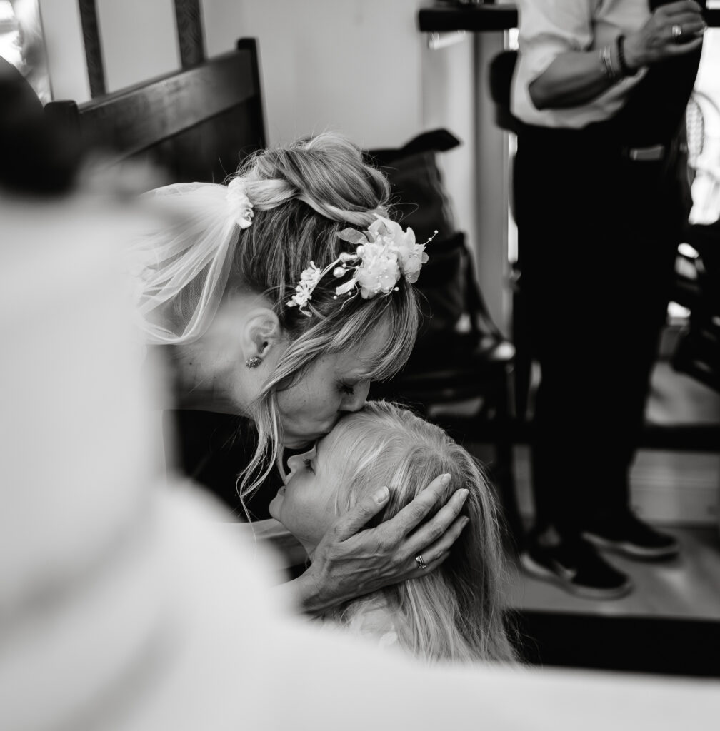 eure Hochzeit in Hamburg. Braut küsst Kind auf die Stirn.
