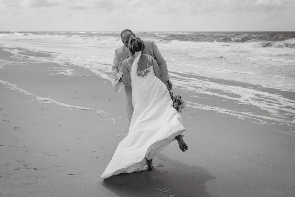 Braut küsst innig ihren Bräutigam Strand. eure Hochzeit in Hamburg